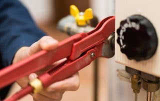 Plumber using tool to work on water heater