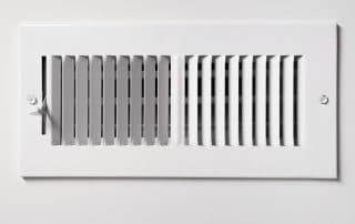 A heating cooling vent register on the wall of a home
