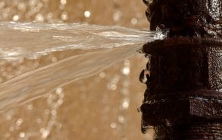 Rusty burst pipe spraying water