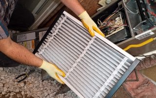 Man working on a furnace changing out a filter