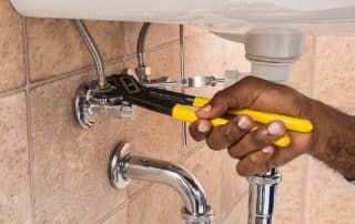 Plumber repairing a sink in a bathroom