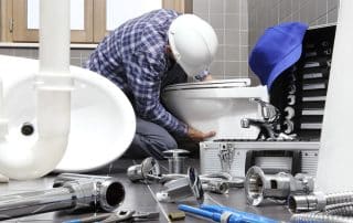 Plumber replacing a toilet in a bathroom