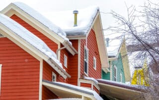 exterior of colorful homes with snow covered roofs